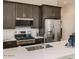 Modern kitchen features stainless steel appliances, dark cabinets, and a center island with seating at 3858 E Kenley Ln, San Tan Valley, AZ 85143