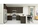 This modern kitchen features dark wood cabinetry, stainless steel appliances, and a breakfast bar at 4571 E French Rd, San Tan Valley, AZ 85143