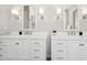 Well-lit bathroom with dual vanities, sleek white cabinets, and modern fixtures and lighting at 504 E Aurora Dr, San Tan Valley, AZ 85140
