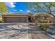 Charming exterior view of a home with a desert landscape and a three-car garage with mature trees at 5077 E Lonesome Trl, Cave Creek, AZ 85331