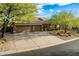 An exterior view of the home featuring desert landscaping, three-car garage and concrete driveway at 5077 E Lonesome Trl, Cave Creek, AZ 85331