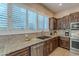 Bright kitchen with stainless steel appliances, stone countertops, and custom wood cabinets at 5077 E Lonesome Trl, Cave Creek, AZ 85331