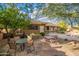 Patio area with stone flooring and outdoor seating, shaded by mature trees at 5077 E Lonesome Trl, Cave Creek, AZ 85331