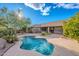 Inviting backyard oasis featuring a freeform pool, mature trees, and ample patio space for outdoor entertaining at 5077 E Lonesome Trl, Cave Creek, AZ 85331