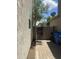 Backyard is paved with walkway to gate, trash bins, and greenery at 6614 W Polk St, Phoenix, AZ 85043