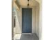Close-up of the blue front door with an overhead light fixture, viewed from the covered porch at 6614 W Polk St, Phoenix, AZ 85043