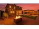 Stunning backyard featuring a fire pit, string lights, covered patio, and well-manicured artificial grass at 6632 W Saguaro Park Ln, Glendale, AZ 85310