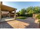 Wide shot of backyard featuring pergola, artificial turf, covered patio, and brick hardscape at 6632 W Saguaro Park Ln, Glendale, AZ 85310