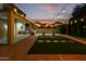 Backyard oasis with a covered patio, built-in grill, artificial turf, and string lights for evening entertainment at 6632 W Saguaro Park Ln, Glendale, AZ 85310