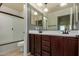 Well-lit bathroom featuring a double vanity, a shower with tile accents, and elegant fixtures at 6632 W Saguaro Park Ln, Glendale, AZ 85310