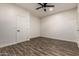 Simple bedroom boasts wood-look floors, ceiling fan, and plenty of open space at 6632 W Saguaro Park Ln, Glendale, AZ 85310