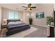 A bright bedroom featuring a large bed, ceiling fan, and television set against the wall at 6632 W Saguaro Park Ln, Glendale, AZ 85310