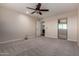 Spacious bedroom features a ceiling fan, a large window, and a mirror with a partial view into the bathroom at 6632 W Saguaro Park Ln, Glendale, AZ 85310