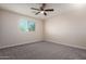 Bright bedroom features neutral carpet and a ceiling fan for added comfort at 6632 W Saguaro Park Ln, Glendale, AZ 85310