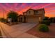 Beautiful two-story home featuring desert landscaping and a two car garage at dusk with colorful skies at 6632 W Saguaro Park Ln, Glendale, AZ 85310