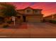 Charming two-story home with desert landscaping, brick accents, and a two-car garage against colorful dusk sky at 6632 W Saguaro Park Ln, Glendale, AZ 85310