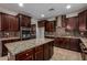 Expansive kitchen featuring an island, dark wood cabinets, and stainless steel appliances at 6632 W Saguaro Park Ln, Glendale, AZ 85310