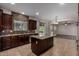 View of the open kitchen with an island, stainless steel appliances, and dark cabinets at 6632 W Saguaro Park Ln, Glendale, AZ 85310