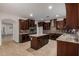 Open kitchen with center island, dark cabinetry, and granite countertops at 6632 W Saguaro Park Ln, Glendale, AZ 85310