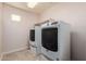 Bright laundry room featuring a full-size washer and dryer and built-in shelves for optimal storage at 6632 W Saguaro Park Ln, Glendale, AZ 85310