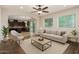 Comfortable living room with dark hardwood floors, neutral furniture, and views to kitchen area at 6632 W Saguaro Park Ln, Glendale, AZ 85310
