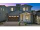 Beautiful two-story home with a modern design, visible in the evening light with illuminated windows at 6722 N 9Th Dr, Phoenix, AZ 85013