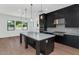 Modern kitchen with island, stainless steel appliances, dark cabinets, and wood flooring at 6722 N 9Th Dr, Phoenix, AZ 85013