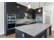 Modern kitchen with dark cabinetry, stainless steel appliances, and a sleek marble-topped island for cooking at 6722 N 9Th Dr, Phoenix, AZ 85013