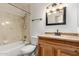 Traditional bathroom featuring a shower-tub combo and a wood vanity with stone countertop at 6932 E Latham St, Scottsdale, AZ 85257