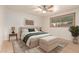 Inviting bedroom features neutral decor, ceiling fan, rug, and a bright window overlooking the landscape at 6932 E Latham St, Scottsdale, AZ 85257