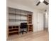 Bedroom with built-in shelving and desk area, complemented by hardwood floors and a ceiling fan at 6932 E Latham St, Scottsdale, AZ 85257