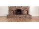 Close-up of brick fireplace with decorative arched inserts and wooden flooring at 6932 E Latham St, Scottsdale, AZ 85257