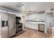 Well-lit kitchen features stainless steel appliances, white cabinetry, and light wood-look floors at 6932 E Latham St, Scottsdale, AZ 85257