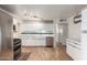 Bright kitchen with white cabinetry, stainless steel appliances, light hardwood floors, and track lighting at 6932 E Latham St, Scottsdale, AZ 85257