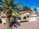 Attractive single-story home showcasing a spacious driveway, brick detailing, and beautiful palm trees at 811 S 79Th Way, Mesa, AZ 85208