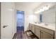 Bright bathroom featuring double sink vanity with wood-look floors and separate toilet room at 8943 W Sierra Vista Dr, Glendale, AZ 85305