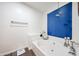 Bathroom featuring soaking tub with blue blinds over the window and wood-look floors at 8943 W Sierra Vista Dr, Glendale, AZ 85305