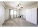 Bright bedroom with large windows, ceiling fan, carpet floors, and a built in white storage cabinet at 9243 W Palmer Dr, Peoria, AZ 85345