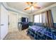 Cozy bedroom features a ceiling fan, plush carpet, and a charming blue accent wall, creating a warm and inviting space at 9243 W Palmer Dr, Peoria, AZ 85345