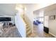 Hallway with wood-look tile flooring, a staircase, and entry to the living room at 9243 W Palmer Dr, Peoria, AZ 85345