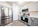 Modern kitchen featuring stainless steel appliances, gray cabinets and wood-look tile flooring at 9243 W Palmer Dr, Peoria, AZ 85345