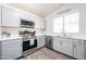 Well-lit kitchen features stainless steel appliances, gray cabinets, and wood-look floors at 9243 W Palmer Dr, Peoria, AZ 85345