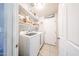A spacious laundry room with washer, dryer, shelving, and convenient access to an exterior door at 9243 W Palmer Dr, Peoria, AZ 85345
