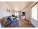 Cozy living room with wood-look tile flooring, comfortable seating, and a large TV at 9243 W Palmer Dr, Peoria, AZ 85345