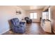 Living room with wood-look tile flooring, a window with blinds, neutral walls and comfortable recliners at 9243 W Palmer Dr, Peoria, AZ 85345