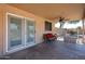 A covered patio features neutral colors, a ceiling fan, a bench and sliding doors to the home's interior at 9243 W Palmer Dr, Peoria, AZ 85345