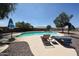 Inviting pool with lounge chairs, surrounded by desert landscaping and a privacy fence, perfect for relaxing at 9243 W Palmer Dr, Peoria, AZ 85345