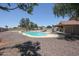 A private fenced pool features an irregular design with a stone surround and lounge chairs at 9243 W Palmer Dr, Peoria, AZ 85345