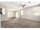 Open-concept living room featuring carpet, a ceiling fan, and natural light at 925 E Agua Fria Ln, Avondale, AZ 85323