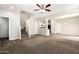 Spacious living room with carpet, a ceiling fan, and views of the stairs and kitchen at 925 E Agua Fria Ln, Avondale, AZ 85323